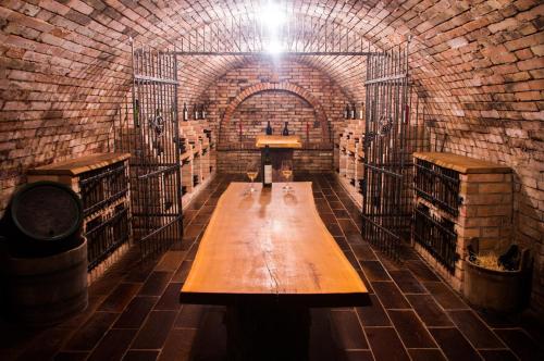 a wine cellar with a wooden table in a brick wall at Vinný sklep a penzion U Vinohradu in Velké Bílovice