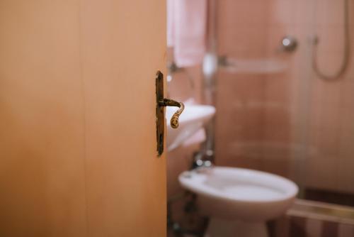 a door to a bathroom with a toilet and a sink at Palazzo Romani Adami in Fermo