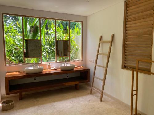 a bathroom with two sinks and a large window at Balian Prana in Selemadeg