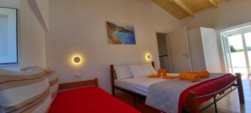 a bedroom with two beds and a red rug at Villa Beloussi Zakynthos in Kipseli