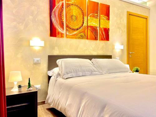 a bedroom with a white bed and a painting on the wall at Casa Nostra in Selva del Montello