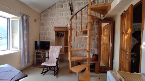 a room with a spiral staircase and a desk at Gudelj Apartments in Perast