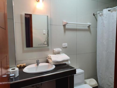 a bathroom with a sink and a toilet and a mirror at GOLDEN SKY in Talara