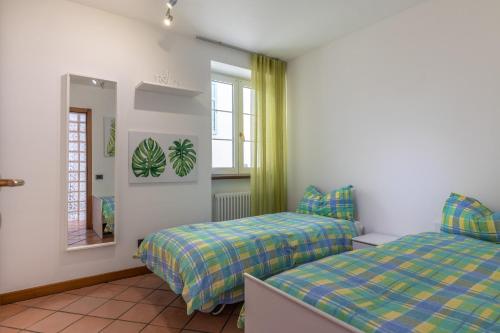 1 dormitorio con 2 camas y espejo en Casa Carraia, en Cembra