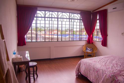 a bedroom with a bed and a large window at HAKS Boutique B&B with Pool & Farm-to-Table Dining in Lahad Datu