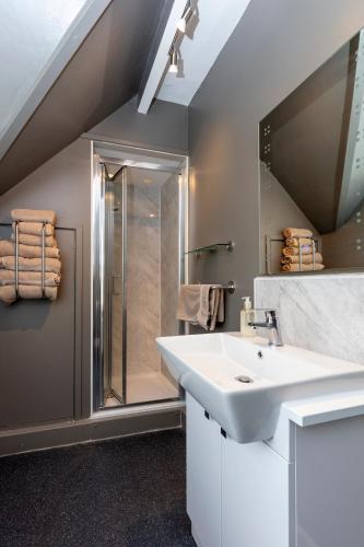 a bathroom with a sink and a shower at The Gillett's Cottage in Wantage