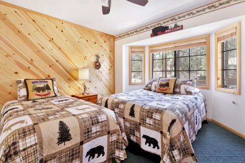 two beds in a room with wood paneling at Retreat to Fox Farm-1662 by Big Bear Vacations in Big Bear Lake