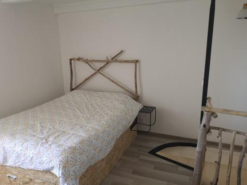 a bedroom with a bed and a white wall at Gite Terradou in Planzolles