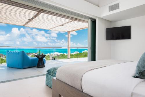 a bedroom with a bed and a view of the ocean at Beach Enclave in Providenciales