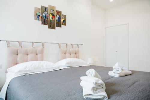 - une chambre avec un lit et des serviettes dans l'établissement Kennedy 54, à Alghero