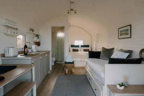 eine Küche und ein Schlafzimmer mit einem Bett in einem Zimmer in der Unterkunft Strathy Bay Pods in Strathy