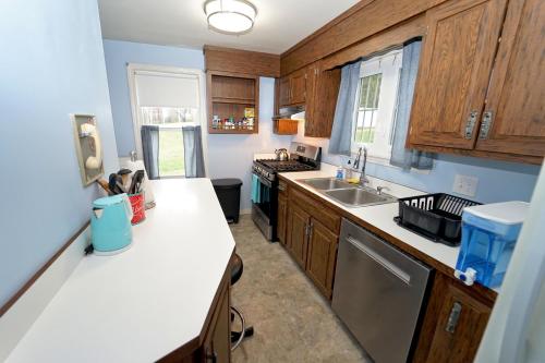 a kitchen with wooden cabinets and a white counter top at Pool house in Plymouth