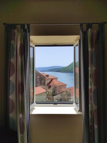 a window in a room with a view of the water at Gudelj Apartments in Perast