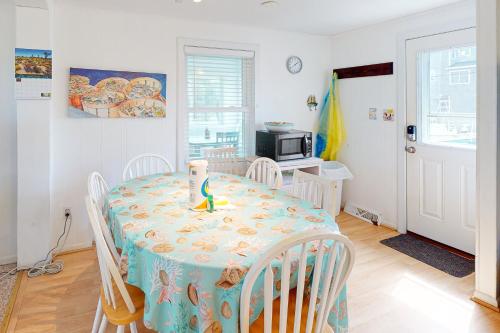 a dining room with a table and chairs and a microwave at Walk the Plank 876 in Hatteras