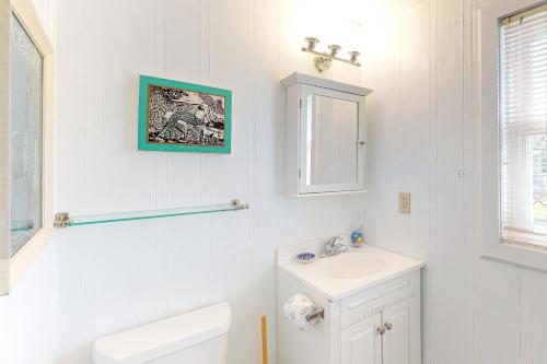 a white bathroom with a toilet and a sink at Walk the Plank 876 in Hatteras