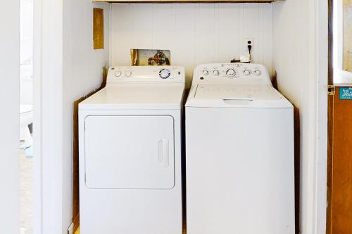 two white washing machines in a small kitchen at Walk the Plank 876 in Hatteras