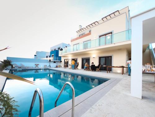 a large swimming pool in front of a building at Wellnesshouse in Atouguia da Baleia