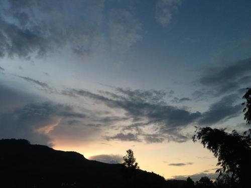 a cloudy sky at sunset with a mountain at Quo Vadis Farm in Māngwa