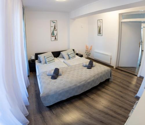 Casa Blanca Apartman في بالاتونفينيفيس: غرفة نوم بسرير كبير عليها وسادتين