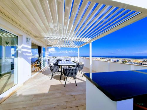 a house with a balcony with a table and chairs at Penthouse Rentalbufeira in Albufeira