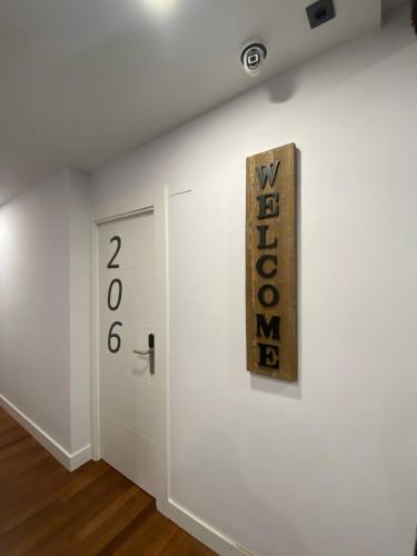 a white wall with a door and a sign on it at Casual Mardones in Bilbao
