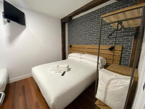 a room with two beds and a brick wall at Casual Mardones in Bilbao