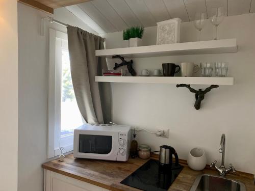 a kitchen with a microwave on a counter next to a window at Giardino Botanico in Ragusa