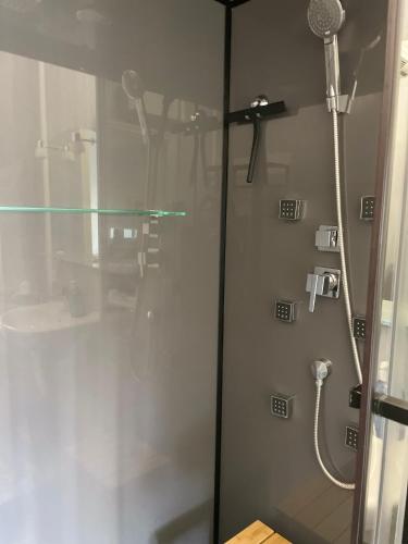 une douche dans une salle de bain avec une porte vitrée dans l'établissement Terrasse Vue Mer, à Villers-sur-Mer