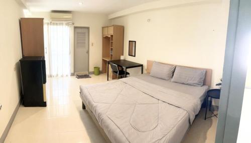 a bedroom with a large bed and a desk at Grand Residence in Bangkok
