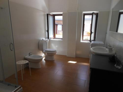 a bathroom with two toilets and two sinks and two windows at Home Patrizia in Acireale