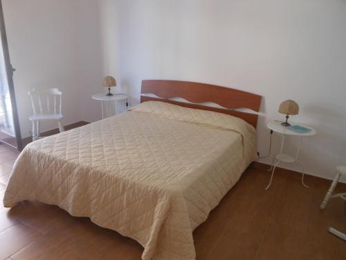 a bedroom with a bed and two tables with lamps at Home Patrizia in Acireale