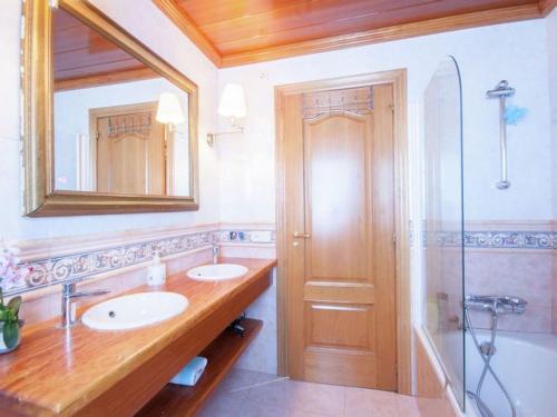 een badkamer met 2 wastafels, een spiegel en een douche bij Cozy holiday home with pool in St Pere Pescador in Sant Pere Pescador