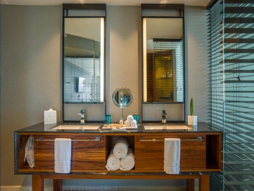 a bathroom with two sinks and two mirrors at Live Aqua Cancun - Adults Only - All-Inclusive in Cancún