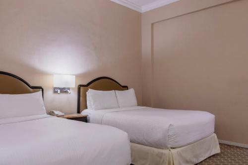 a hotel room with two beds and two lamps at Gamma Monterrey Gran Hotel Ancira in Monterrey