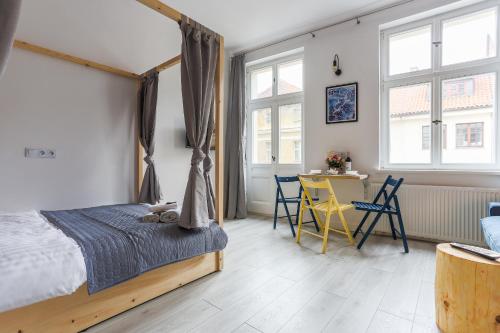 a bedroom with a bed and a table and chairs at Simply Modern Apartments in Toruń