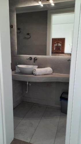 y baño con lavabo y espejo. en Arion suites Mykonos, en Mykonos ciudad