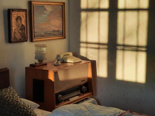 a room with a bed and a telephone on a dresser at House 1797 - Charm of Slovenian Vintage in Dob