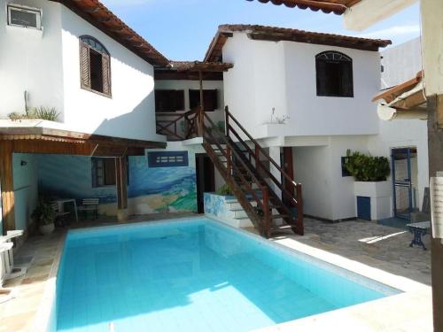a house with a swimming pool in front of a house at Arraial do Cabo - Recanto das Tartarugas - Aluguel Econômico in Arraial do Cabo