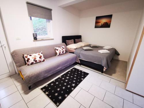 a living room with a couch and a bed at Studio ELLI KOPER in Koper