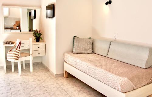 a bedroom with a bed and a desk and a chair at Comfy Loft at Regina Apartments in Alikanas