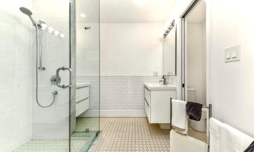 a bathroom with a glass shower and a sink at The Flats West in Wellington