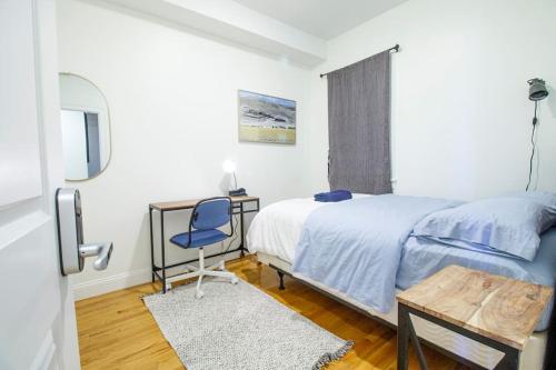 a bedroom with a bed and a desk and a chair at 4BR 1,5BH Sunny Apt in Roxbury in Boston