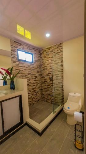 uma casa de banho com um chuveiro e um WC. em Apartamentos Playa Negra em Puerto Viejo