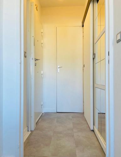 un couloir vide avec une porte blanche dans une chambre dans l'établissement Nice Promenade 2, à Nice