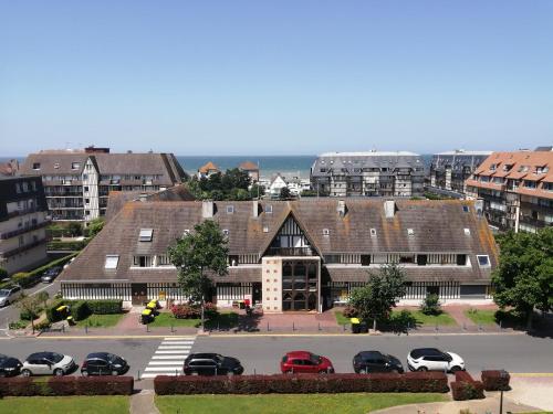 a large building with cars parked in a parking lot at T2 vue mer 6 personnes in Villers-sur-Mer