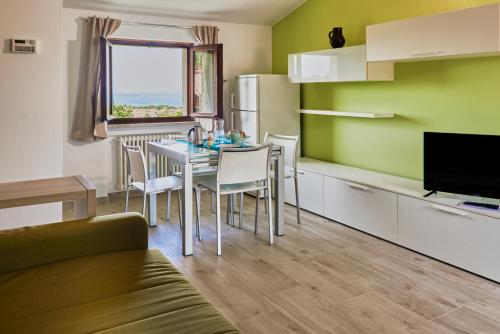 une cuisine et une salle à manger avec une table et des chaises dans l'établissement Appartamenti Hopfen Lazise, à Lazise