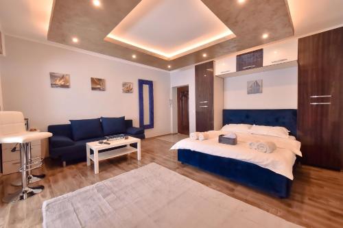 Un dormitorio con una cama, un sofá y una mesa. en Bavaria, en Constanţa