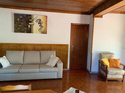 a living room with a couch and a chair at Casa do Bairro Alto in Cerva