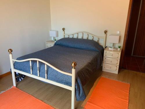 a bedroom with a bed and a nightstand with two lamps at Casa do Bairro Alto in Cerva