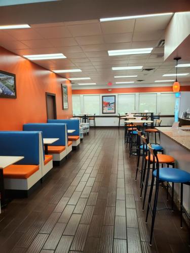 a dining room with tables and blue chairs at Howard Johnson by Wyndham Ocala FL I-75 in Ocala